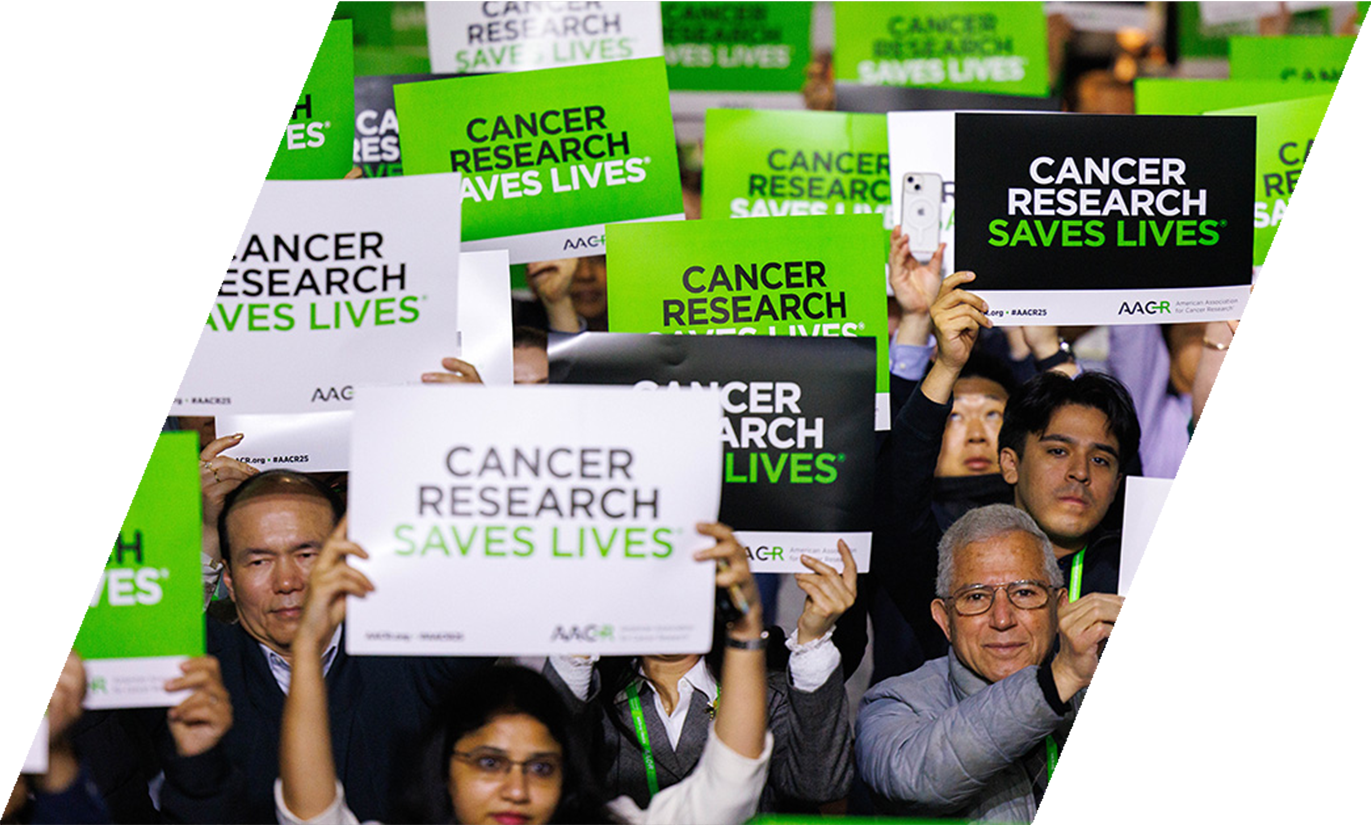 AACR Annual Meeting attendees holding up signs reading Cancer Research Saves Lives
