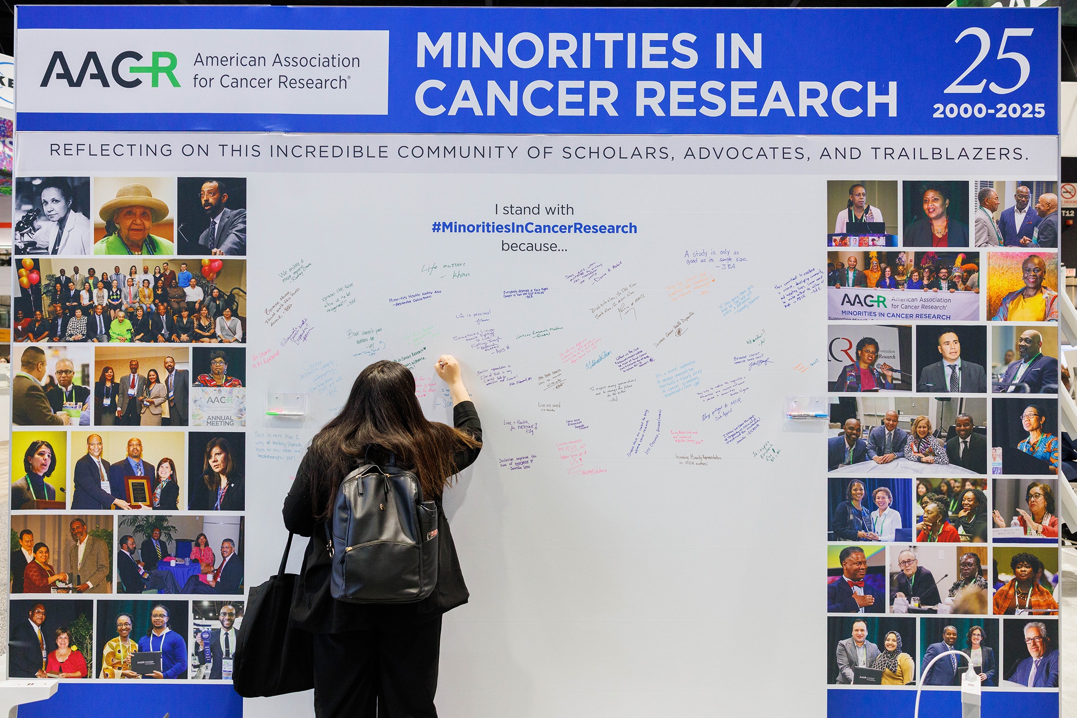 A member of AACR Minorities in Cancer Research signing the 25th anniversary mural.
